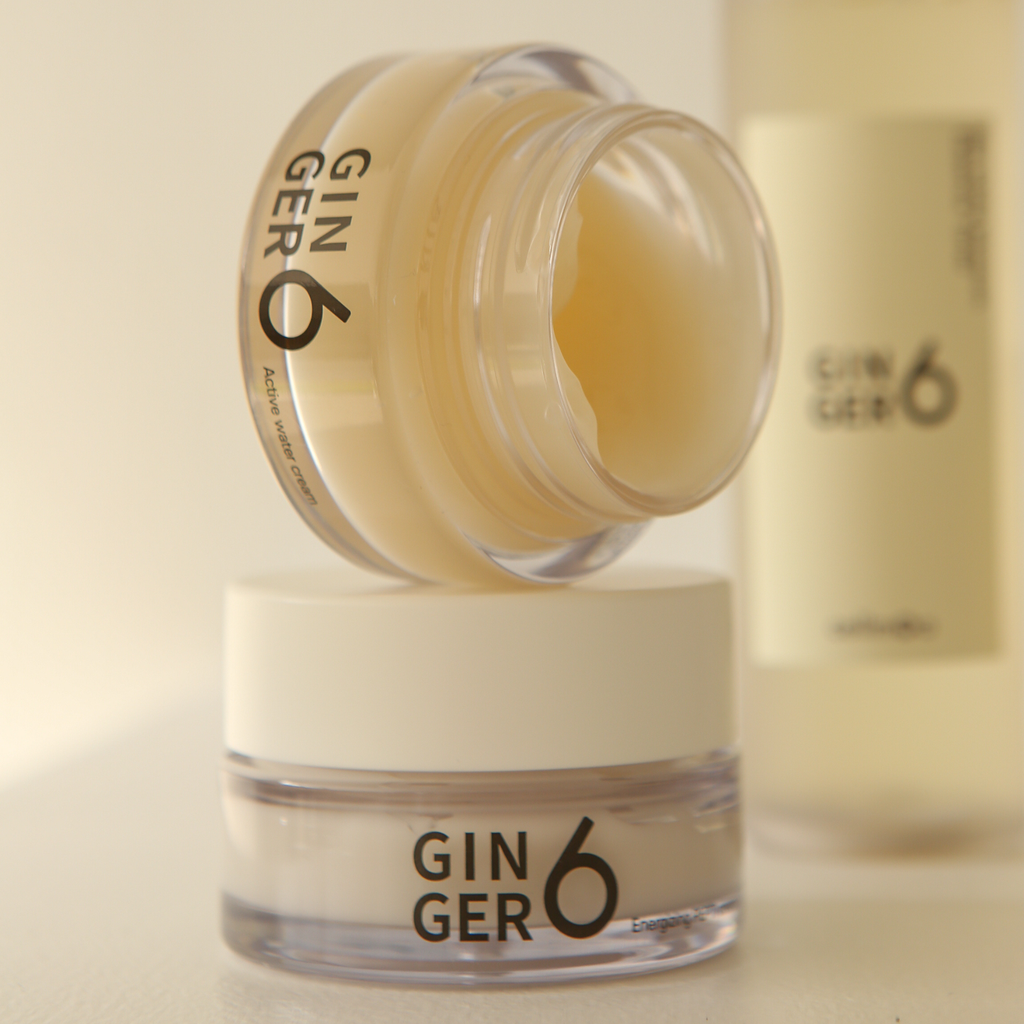 Two jars of Ginger6 Active Water Day Cream stacked, with the top jar open to show the smooth gel cream texture