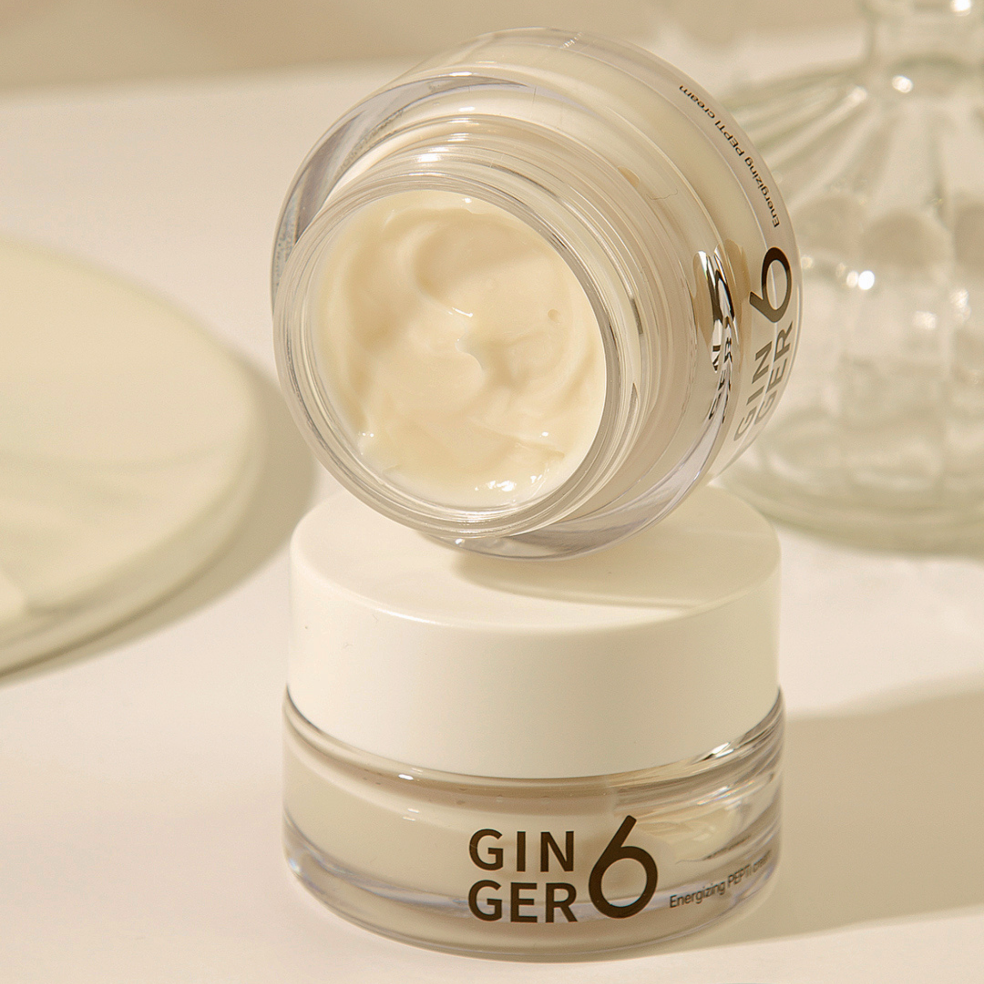 Two jars of Ginger6 Energizing PEPTI Night Cream stacked, with the top jar open to show the rich cream texture