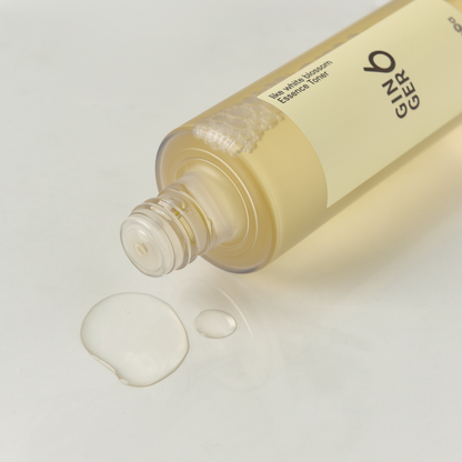 Close-up of Ginger6 Essence Toner bottle dispensing a clear, hydrating liquid drop on a white surface