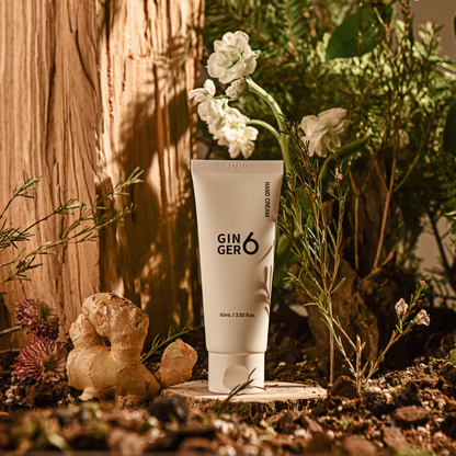 Ginger6 Hand Cream displayed in a natural setting with raw ginger, wood, and green plants