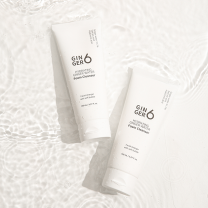 Two tubes of Ginger6 hydrating ginger water foam cleanser lying in clean, rippling water